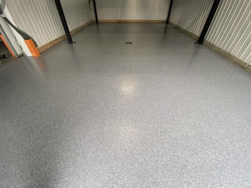 Entrepôt avec plancher à flocons gris clair et structure d'acier