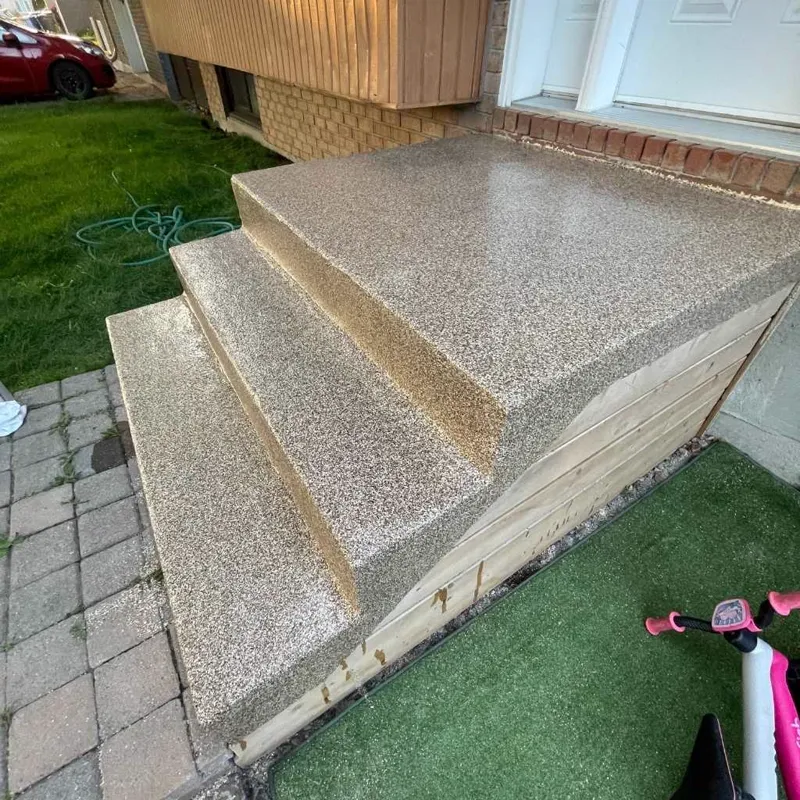 Escalier extérieur en béton avec revêtement beige, gazon autour