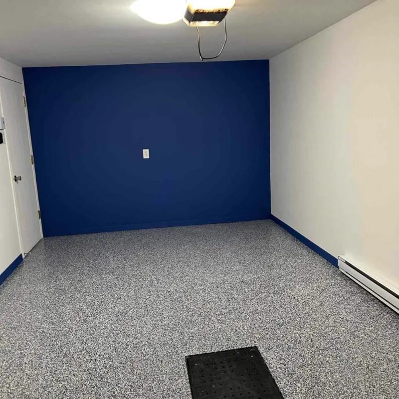 Garage avec plancher à flocons gris et mur d'accent bleu
