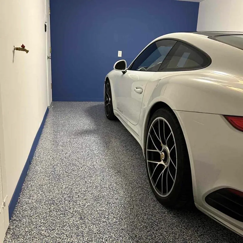 Garage avec plancher à flocons de vinyle gris et voiture sport blanche
