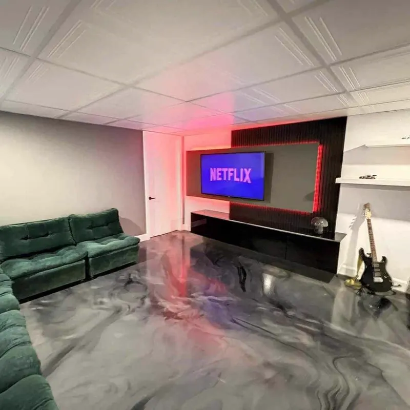 Sous-sol aménagé avec plancher d'époxy métallique noir et gris très réfléchissant