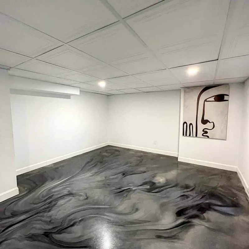 Sous-sol avec plancher d'époxy métallique noir et blanc marbré à Mascouche