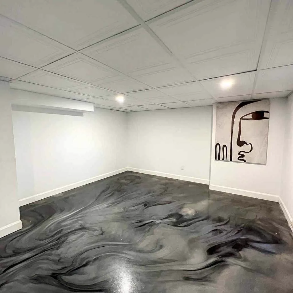 Sous-sol avec plancher d'époxy métallique noir et blanc marbré réalisé à Lachenaie
