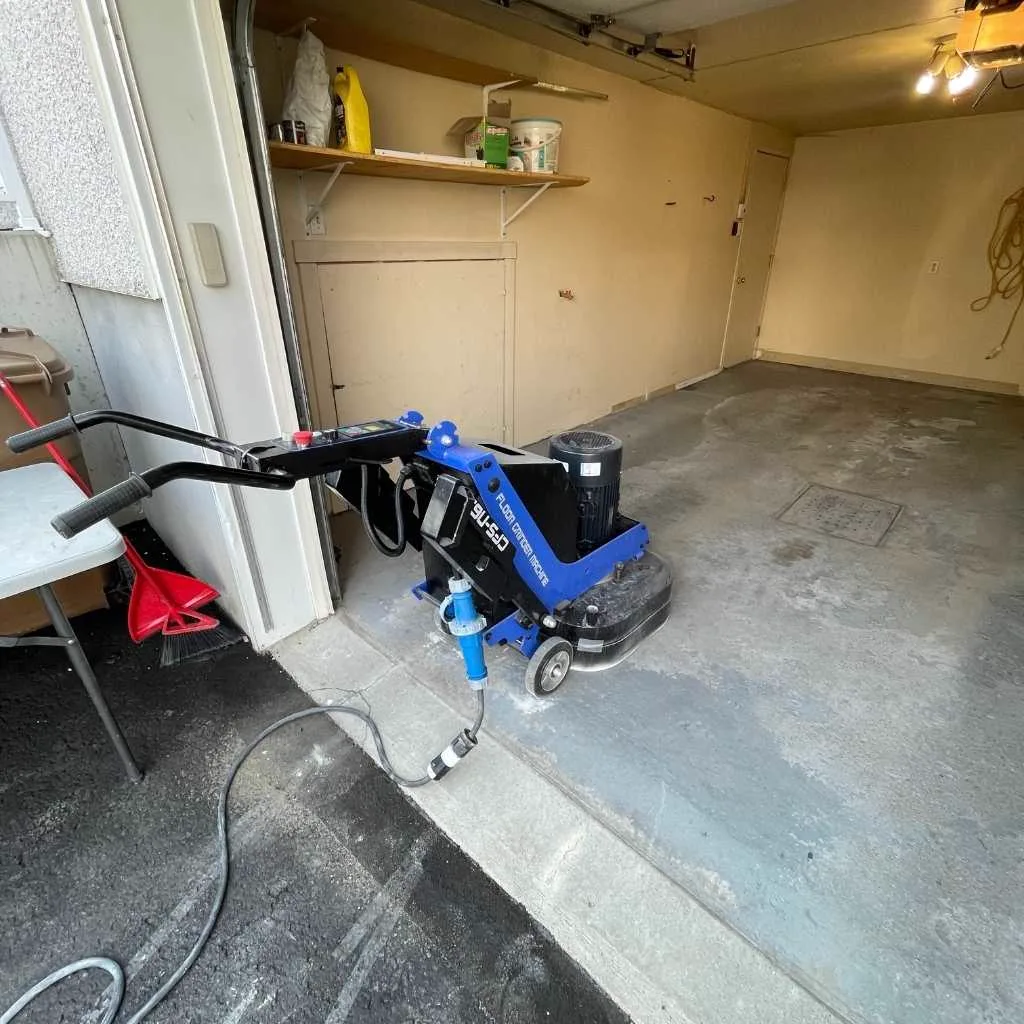 Technicien Soltek meulant la dalle de béton d'un garage avant l'application de l'époxy